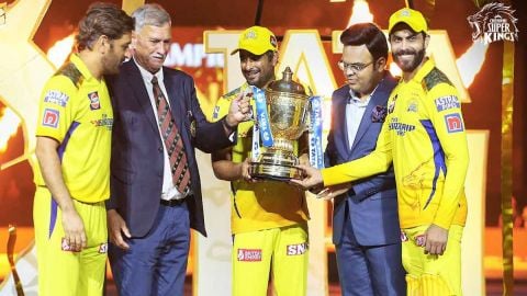 Teammates celebrating with trophy after victory, Dhoni behind