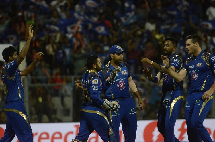 Mumbai Indians players celebrate fall of a wicket 