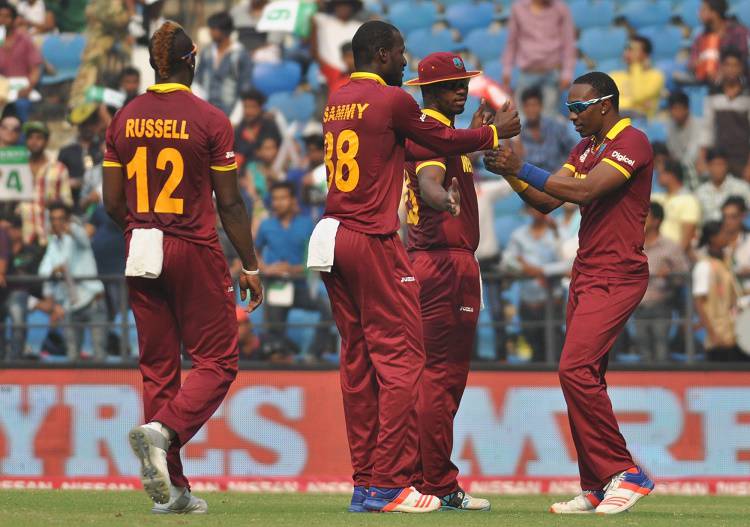 West Indies players celebrate fall of a wicket during  in Tamil